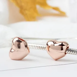 Polished rose gold heart charms on a silver snake chain bracelet for women