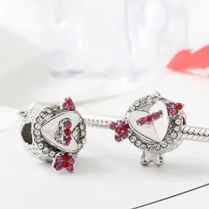 Detailed macro view of heart and cupid arrow charm with gradient pink cubic zirconia