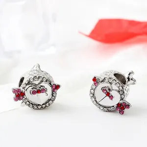 Macro view of silver heart charms with Cupid's arrow and red crystal rhinestones