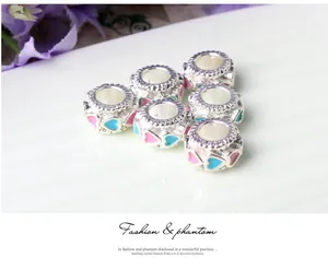 Macro detail of silver large-hole beads with pink and blue enamel heart designs for DIY