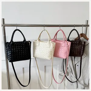 Detail view of woven leather texture and metal buckles on multi-color Boston bags