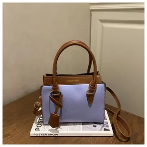 Sac à main minimaliste violet et marron avec coutures contrastées sur table en bois