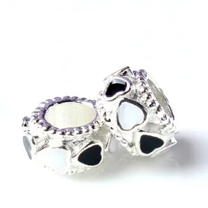 Silver cylinder charm beads with black and white enamel heart patterns for bracelets
