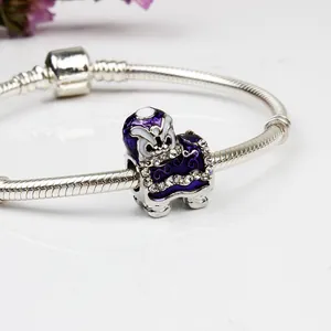 Vista macro di un ciondolo danza del leone in smalto viola con cristalli su bracciale