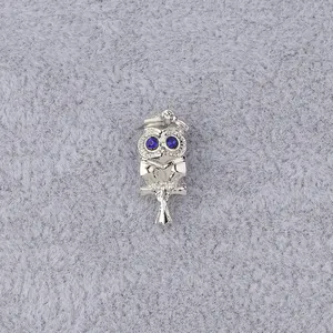 Detailansicht der silbernen Eulen-Charms mit Doktorhut und blauen Edelsteinaugen