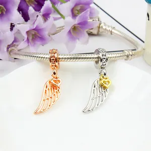 Detail of rose gold and silver angel wing charms with hollow feathers on a snake chain