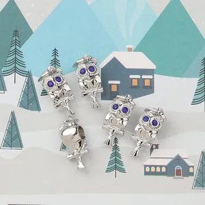 Makrodetail einer silbernen Eule mit Doktorhut und blauen Steinen für DIY Armbänder