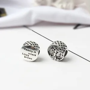 Macro detail of silver Tree of Life charm and engraved Family is where Love Grows bead