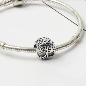 Detailed close-up of tree of life charm bead with hollow hearts on a silver snake chain