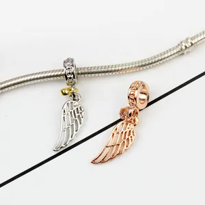Silver and rose gold angel wing charms with hollow feathers on snake chain bracelet