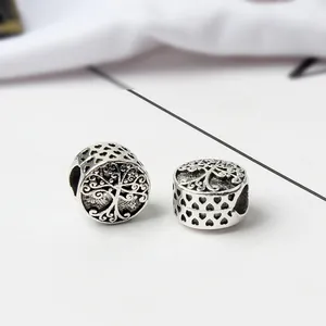 Macro detail of silver tree of life charms with hollow heart patterns for DIY bracelets