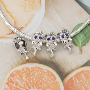 Silbernes Eulen-Armband mit blauen Steinen auf lebhaftem Zitrusfrucht-Hintergrund