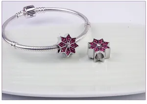 Vista macro de pulsera de cadena de serpiente plateada con dijes de estrellas lilas