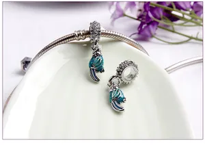 Macro shot of tropical parrot dangle charm with blue enamel and zircon inlay details
