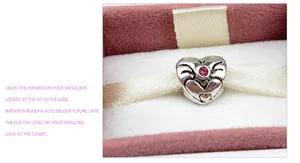 Vue macro d'un charm cœur vintage en argent avec zircon rose dans un coffret cadeau