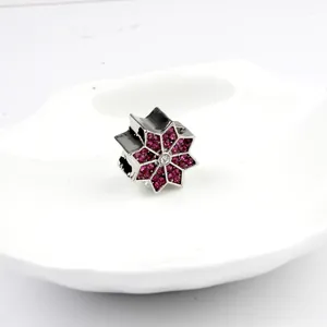 Abalorio de estrella plateada con cristales morados y circón en plato blanco