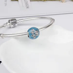 Blue enamel paw print bead charm on silver snake chain bracelet with white crystals