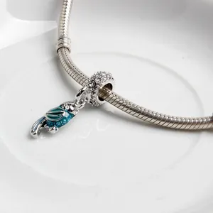 Silver snake chain bracelet with a colorful blue and green parrot pendant and zircons