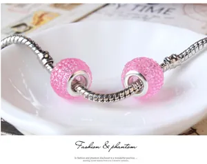 Macro detail of pink resin candy beads on a silver snake chain bracelet