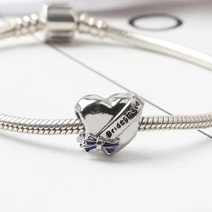 Gros plan du charm en forme de cœur Bridesmaid avec nœud violet sur chaîne argent