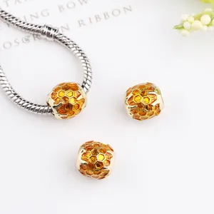 Golden honeycomb beads with amber enamel inlay on silver snake chain bracelet