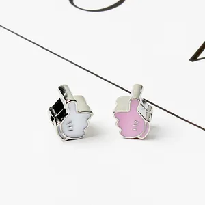 Macro shot of thumbs up charm beads in pink and white enamel for DIY bracelet making