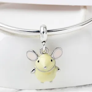 Macro shot of cute yellow enamel mouse pendant with pink ears on silver bracelet