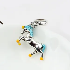 Macro shot of silver horse charm with blue and yellow enamel details for DIY jewelry