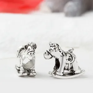 Macro view of retro silver rocking horse charms with oxidized vintage metal details