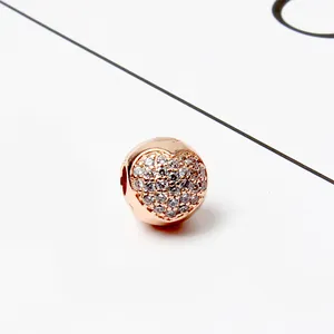Macrofoto van roségouden hartbedel met witte zirkonia voor een doe-het-zelf-armband
