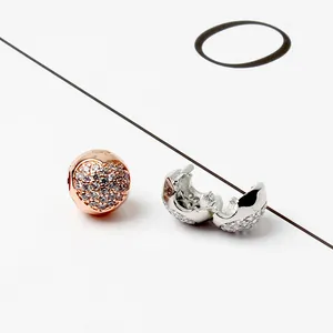 Macro-opname van zilveren en roségouden hartbedeltjes met pavé-stenen voor DIY-armbanden
