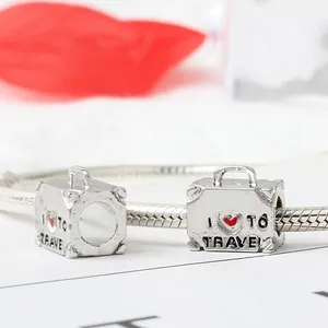 Silver suitcase bead with 'I love to travel' engraving on a snake chain bracelet