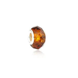 Close-up of faceted amber glass charm bead with silver metal core for DIY bracelets