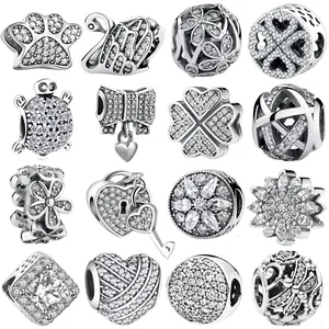 Macro display of assorted silver DIY beads with zircons in swan and clover shapes