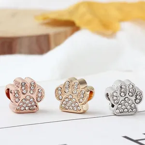 Detalle de abalorios de huella animal con circonitas en acabados oro rosa, dorado y plata