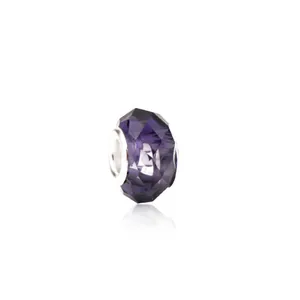 Macro shot of faceted purple crystal glass charm with silver metal core for DIY bracelet
