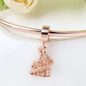 Rose gold European castle charm with detailed spires on a rigid metal bangle bracelet
