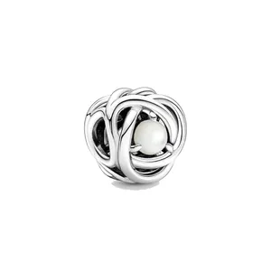 Vue détaillée du charm en argent avec nœud entrelacé et une perle blanche centrale