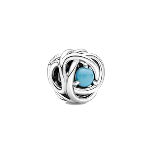 Vue détaillée du charme en argent entrelacé avec une perle de naissance bleue