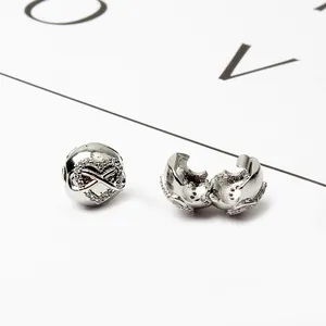 Dettaglio macro della perla a cuore in lega d'argento con simbolo infinito e zirconi