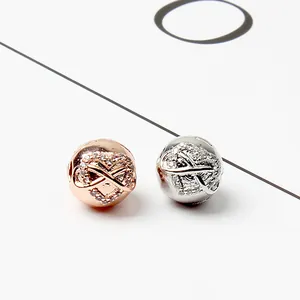 Dettaglio charm a cuore in oro rosa e argento con simbolo infinito e cristalli incastonati