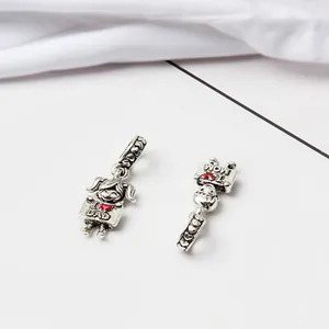 Détail des charms rétro en argent avec gravures de cœurs I Love Dad et Mom