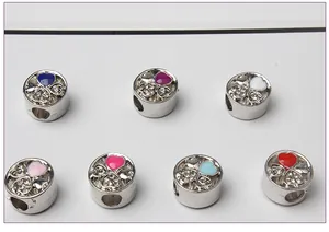 Close-up of seven heart-shaped clover beads with colorful enamel and inset crystals