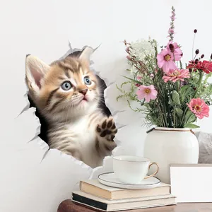 Detail view of 3D kitten wall sticker peeping through a crack on a white wall decor
