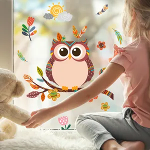 Détail de stickers hibou et fleurs appliqués par une fille dans une pièce lumineuse