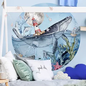 Detail of round ocean wall decal featuring blue whales and lighthouse on a child's bedroom wall