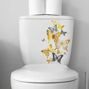 Adesivi farfalla dorati e neri che decorano la cassetta del water in ceramica