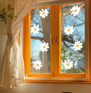 Close-up of small white daisy window stickers on glass for cozy home wall decoration