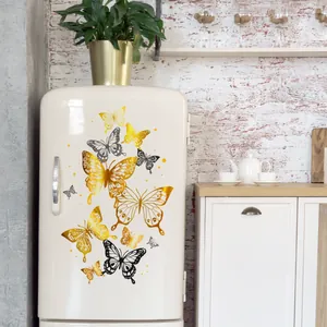 Adesivi murali farfalla 3D in oro e nero su un frigorifero vintage in cucina