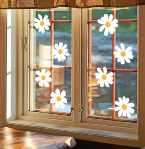 Detailed view of eight white daisy flower stickers applied to a clear glass window pane